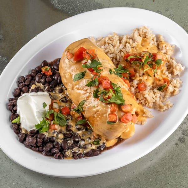 Raging Burrito's wet burrito covered in cheese sauce, pico de gallo, with black beans, sour cream, and rice.