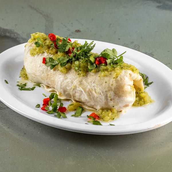 A Raging Burrito, generously topped with green salsa, fresh cilantro, and diced red peppers.